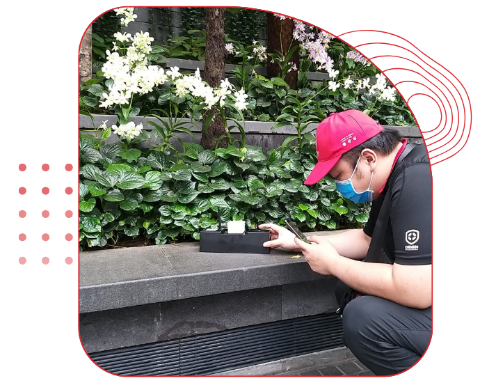 ORIGIN Exterminators technician conducting pest inspection in outdoor commercial area